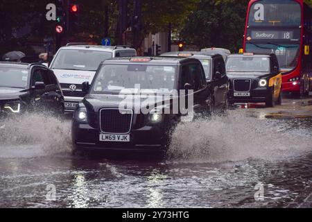 London, Großbritannien. September 2024. Ein Taxi plätschert durch eine wasserdichte Euston Road, während in England bei starkem Regen Hochwasserwarnungen ausgegeben werden. (Foto: Vuk Valcic/SOPA Images/SIPA USA) Credit: SIPA USA/Alamy Live News Stockfoto