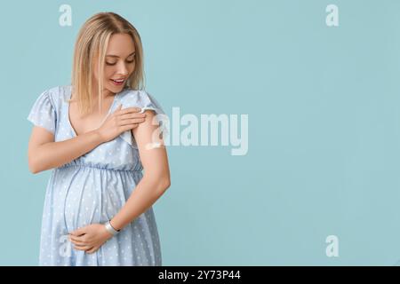 Junge Schwangere nach Impfung auf blauem Hintergrund Stockfoto