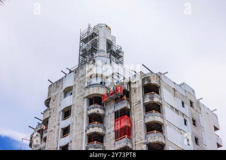 Renovierungsarbeiten an Hochhäusern mit Bauarbeitern auf der Plattform in Miami Beach, Florida. USA. Stockfoto