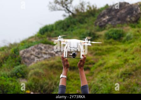 Ein Pilot, der während der Landung an einer Quadcopter-Drohne festhält Stockfoto