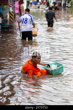 Straßenarbeiter entfernen Ablagerungen aus einem Abfluss nach Sturzfluten, die durch anhaltende Regenfälle verursacht werden. Die Überschwemmungen in Chiang Mai wurden durch anhaltende Regenfälle und Elektronikläden verursacht, was dazu führte, dass der Abfluss von Doi Suthep in tief liegende Gebiete fließt. Der starke Regen führte auch dazu, dass der Ping River an mehreren Stellen in der Stadt überlief, was zu Schäden an Häusern und Verkehrsstaus auf vielen Straßen führte. Stockfoto