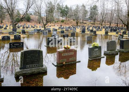 Saint John, NB, Kanada - 30. März 2024: Ein überfluteter Friedhof. Wasser umgibt viele der Grabmarkierungen. Bedeckter Himmel. Stockfoto