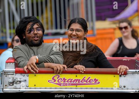 Saint John, NB, Kanada - 22. Juni 2024: Ein Paar reitet auf einer lokalen Messe auf dem Scrambler. Beide scheinen glücklich zu sein und Spaß zu haben. Stockfoto