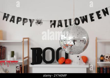 Disco Ball und Halloween Dekoration am Kamin in der Nähe der weißen Wand zu Hause Stockfoto