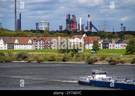 Frachtschiff auf dem Rhein bei Duisburg-Laar, Häuser an der Deichstrasse, Industriekulisse des ThyssenKrupp Steel Stahlwerk in Bruckhausen, NRW, Deutschland, Industriekulisse DU *** Frachtschiff auf dem Rhein bei Duisburg-Laar, Häuser an der Deichstraße, industrielle Kulisse des Stahlwerks ThyssenKrupp in Bruckhausen, NRW, Deutschland, industrielle Kulisse DU Stockfoto