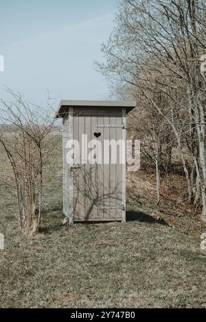 Eine Toilette im Retro-Stil im Freien mit einem Herzen an der Tür im Frühling Stockfoto