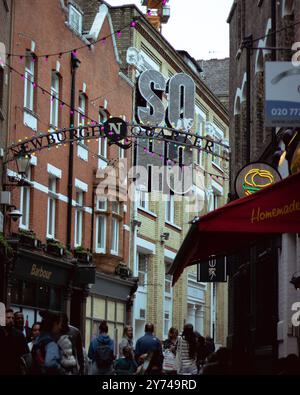 London, England, April 30 2023: Blick auf die Carnaby Street mit Menschen, die herumlaufen, und einem soho-Schild Stockfoto