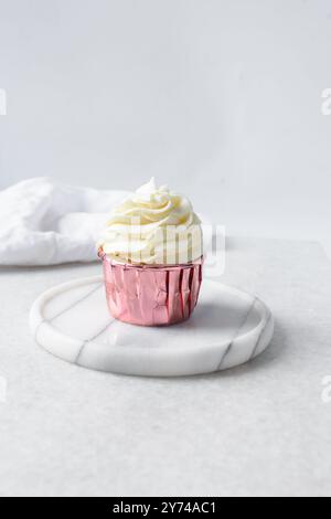 Rosafarbene Cupcakes mit hohem Buttercremewirl, Cupcakes in rosafarbenen Folieneinlagen mit Vanille-Buttercreme, mattierte Cupcakes auf weißem Hintergrund Stockfoto