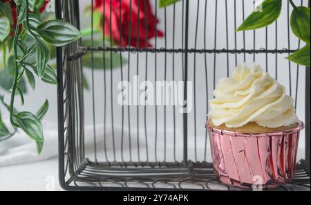 Rosafarbene Cupcakes mit hohem Buttercremewirl, Cupcakes in rosafarbenen Folieneinlagen mit Vanille-Buttercreme, mattierte Cupcakes auf weißem Hintergrund Stockfoto