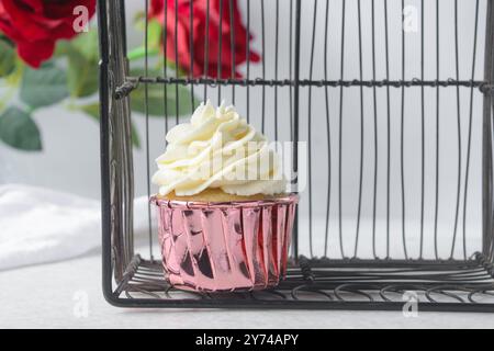 Rosafarbene Cupcakes mit hohem Buttercremewirl, Cupcakes in rosafarbenen Folieneinlagen mit Vanille-Buttercreme, mattierte Cupcakes auf weißem Hintergrund Stockfoto