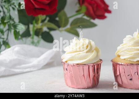 Rosafarbene Cupcakes mit hohem Buttercremewirl, Cupcakes in rosafarbenen Folieneinlagen mit Vanille-Buttercreme, mattierte Cupcakes auf weißem Hintergrund Stockfoto