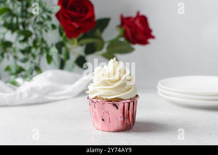 Rosafarbene Cupcakes mit hohem Buttercremewirl, Cupcakes in rosafarbenen Folieneinlagen mit Vanille-Buttercreme, mattierte Cupcakes auf weißem Hintergrund Stockfoto