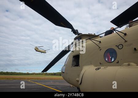 Ein CH-47F Chinook Transporthubschrauber des 1. Bataillons, 169th Aviation Regiment (General Support), Connecticut Army National Guard, fliegt an einem ihrer Schwesterflugzeuge vorbei, die routinemäßig in der Connecticut Army National Guard Aviation Support Facility, Windsor Locks, Connecticut, 27. September 2024 gewartet werden. Die Chinook und ihre fünf Soldaten fliegen auf Anfrage der North Carolina National Guard nach North Carolina, um Katastrophenhilfe als Reaktion auf Hurrikan Helene zu unterstützen. Ihre einwöchige Mission wird es sein, beim Transport von Nahrungsmitteln und Wasser zu helfen Stockfoto