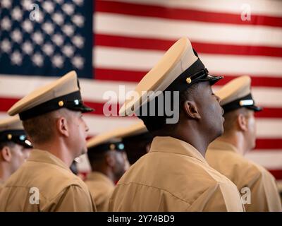 NORFOLK, V.A. (27. September 2024) Chief Petty Officers, die dem größten Flugzeugträger der Welt, USS Gerald R. Ford (CVN 78), zugeteilt wurden, Sing Anchors Aweigh während des Abschlusses einer Ansteckungszeremonie des Chief Petty Officers in der Hangar Bay am 27. September 2024. Ford befindet sich derzeit an der Pier-Seite der Marinestation Norfolk und führt routinemäßige Wartungsarbeiten durch. (Foto der US Navy von Seaman Tajh Payne, Spezialist für Massenkommunikation) Stockfoto