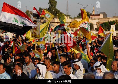 Mossul, Irak. September 2024. Die Anhänger der bewaffneten Gruppe Kataeb Sayyid al-Shuhada (Mitglied der gehashten al-Shaabi/Volksmobilisierungstruppen (PMF)) halten während eines Solidaritätsgebietes gegen die israelische Aggression auf Libanon und Palästina in der Nähe der Großen Moschee (nicht im Blick) von Mossul im Irak eine Fahne. (Foto: Ismael Adnan/SOPA Images/SIPA USA) Credit: SIPA USA/Alamy Live News Stockfoto