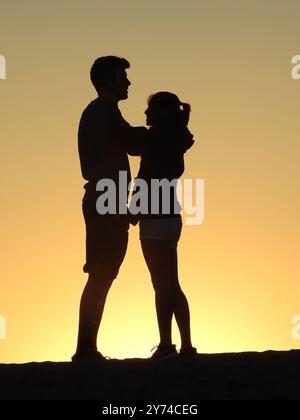 Eine Reihe von fesselnden Silhouetten, die ein Paar mit zarten Momenten bei Sonnenuntergang zeigt und eine ruhige und romantische Atmosphäre schafft. Stockfoto