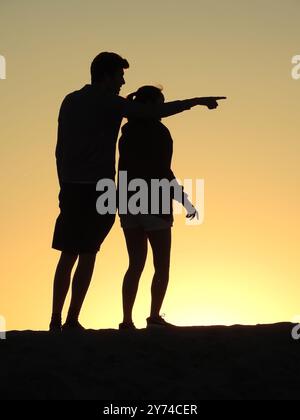 Eine Reihe von fesselnden Silhouetten, die ein Paar mit zarten Momenten bei Sonnenuntergang zeigt und eine ruhige und romantische Atmosphäre schafft. Stockfoto