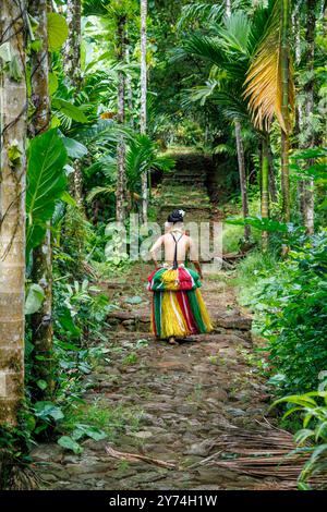 Die gebürtige Yapese in traditioneller Kleidung, auf einem alten Steinweg in ihrem Dorf auf der Insel Yap, Mikronesien, abgebildet. Stockfoto