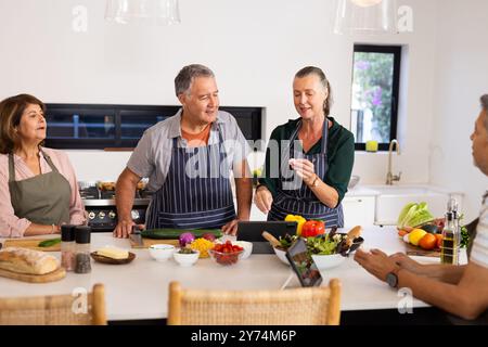 Gemeinsam kochen, Senioren verschiedene Freunde, die gesunde Mahlzeiten in der modernen Küche zubereiten, zu Hause Stockfoto