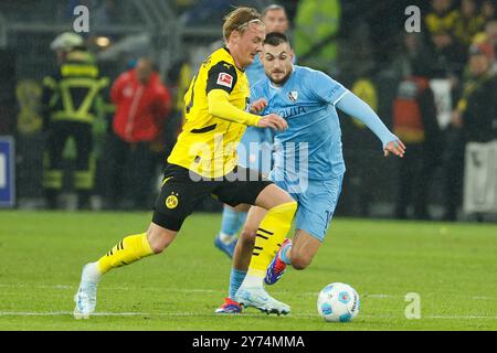 Dortmund, Deutschland. September 2024. Julian Brandt (L) von Borussia Dortmund streitet mit Matus Bero vom VfL Bochum während des ersten Liga-Fußballspiels zwischen Borussia Dortmund und VfL Bochum in Dortmund, 27. September 2024. Quelle: Joachim Bywaletz/Xinhua/Alamy Live News Stockfoto