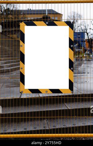 Leeres Bauschild auf einem gelben Zaun in einer Stadt Stockfoto