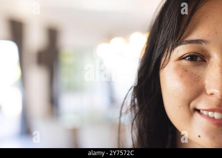 Lächelnde Frau mit langen Haaren genießt die Zeit mit verschiedenen Freunden drinnen, im Kopierraum, zu Hause Stockfoto