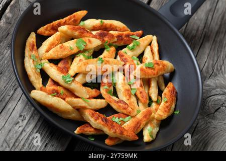 Schupfnudeln, Fingernudel, deutsche Kartoffeldicknudeln, Klöße in einer Pfanne auf rustikalem Holztisch, Nahaufnahme, niederländischer Blickwinkel Stockfoto