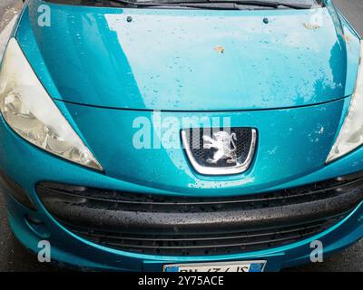 Cremona, Italien 26. September 2024 Nahaufnahme einer blauen peugeot 207 Front, mit Wassertropfen auf der Motorhaube nach dem Regen Stockfoto