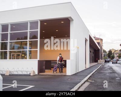 Cremona, Italien 26. September 2024 Ein Mann läuft mit einem Einkaufswagen von einem eurospar-Supermarkt weg, nachdem er seinen Einkauf gemacht hat Stockfoto