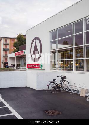 Cremona, Italien 26. September 2024 vor einem eurospar-Supermarktgebäude mit großen Fenstern steht Ein Fahrrad Stockfoto