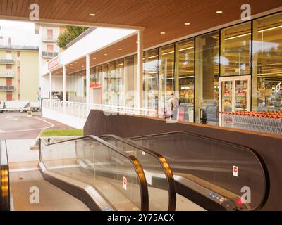 Cremona, Italien 26. September 2024 moderner Supermarkt mit Glaswänden und Rolltreppen, der zum Eingang führt und von einem Kunden betreten wird Stockfoto