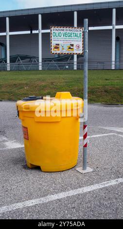 Cremona, Italien 26. September 2024 großer gelber Kunststofftank zum Recycling von gebrauchtem Speiseöl, im Freien auf einem Parkplatz Stockfoto