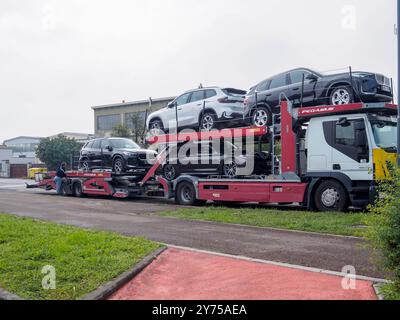 Cremona, Italien 26. September 2024 Ein Lkw-Fahrer sichert sich neue suvs auf einem Auflieger zur Lieferung an einen Händler Stockfoto