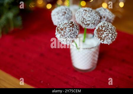 Schokoladenkuchen mit Kokosnussspänen werden in einem Glas bei einer Feier präsentiert, umgeben von festlichen Dekorationen. Stockfoto