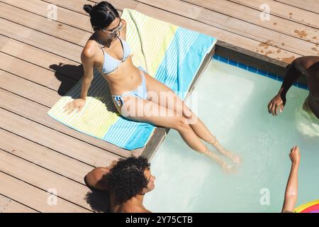 Entspannen Sie am Pool, verschiedene Freunde genießen den sonnigen Tag und treffen Sie sich zu Hause zusammen Stockfoto