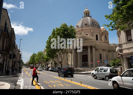 Messina, Italien - 21. Mai 2024: Messina Cityscape entlang des Corso Cavour mit der Kirche Chiesa di Sant'Antonio Abate im Hintergrund. Ein Mann cro Stockfoto