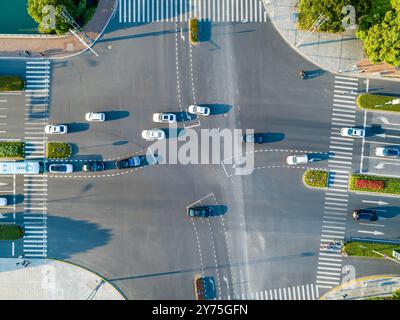 Luftaufnahme einer stark frequentierten Kreuzung mit Fahrzeugen, die bei Tageslicht in einem modernen Stadtgebiet verkehren Stockfoto