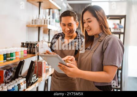 Mitarbeiter überprüfen die angezeigten Produkte mit einem Tablet Stockfoto