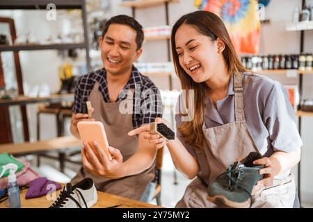 Glückliche Arbeiter lachen über etwas am Telefon Stockfoto