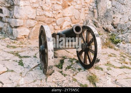 Kanone auf einer Kutsche auf einem Sockel aus weißem Stein in der Nähe des Arsenalgebäudes in Mirow Castle. Standorte in Polen. Architektur des Welttourismus. Stockfoto