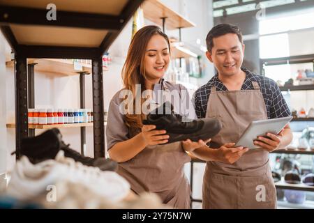 Weibliche Mitarbeiter überprüfen die Farbvorräte auf dem Display Stockfoto