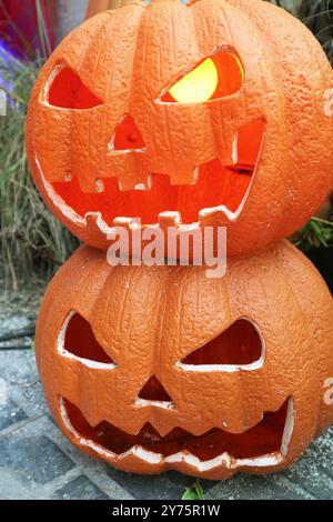 Stapel beleuchteter Halloween Jack O Lantern Kürbisse im Yard Stockfoto