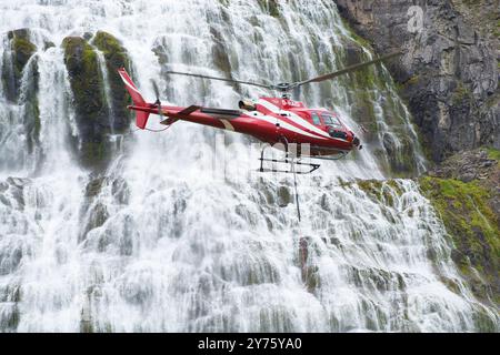 Der Airbus-Hubschrauber H125 fliegt in der Nähe eines Dynjandi-Wasserfalls in der Region Westfjords in Island Stockfoto