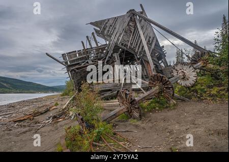 Überreste eines Schaufelrads von einem Schiffswrack am Ufer des Yukon River in Dawson City, Yukon, Kanada Stockfoto