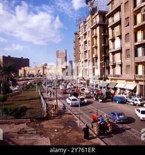 Tägliches Verkehrschaos auf der Meret Basha Straße mit Blick auf das Ägyptische Museum (Kuppel) und den Ramses Hotelturm in Kairo, nahe vom Midan al Tahrir Platz, Ägypten um 1987. Stockfoto