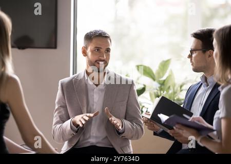 Positiver, erfolgreicher, gutaussehender Geschäftsleiter im Gespräch mit dem Team Stockfoto
