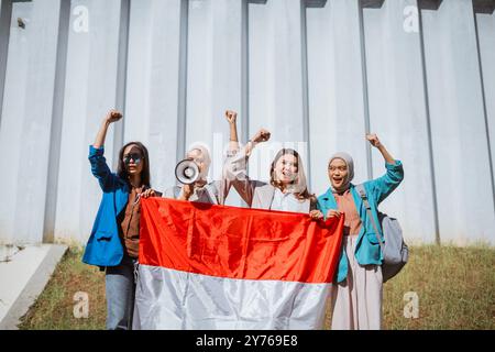 Empowered Women, die gemeinsam mit der indonesischen Flagge für Wandel und Gleichstellung zusammentreffen Stockfoto