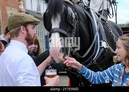 Lacock;, Großbritannien. September 2024. Traditionelle Bierlieferung. Das Red Lion Inn in Lacock hat heute einige besondere Besucher. Die Wadworth Brewery liefert Bier auf traditionelle Weise in die Pubs in der Nähe der Brauerei, mit einem Wagen oder einer Dray, der von einem prächtigen Pferd gezogen wird, aber manchmal nimmt das Team mit dem LKW einen Besuch in ihren Lieblings-Pubs in Wiltshire. Unberührtes Lacock Village ist ein beliebtes Filmset, das in den Filmen Downton Abbey und Harry Potter zu sehen war. Quelle: Mr Standfast/Alamy Live News Stockfoto