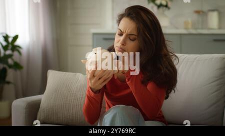 Verpönt ernsthaft kaukasische traurige depressive Frau weibliche Mädchen Klientenkäuferin prüft Schecks Quittungen Steuerrechnungen schütteln leere Schweinebank, kein Geld bezahlt Stockfoto