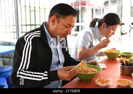 (240928) -- YINCHUAN, 28. September 2024 (Xinhua) -- dieses Foto vom 26. September 2024 zeigt Isidro Castaneda Silva, der Nudeln in einem Restaurant in Yinchuan, Nordwestchinas autonomer Region Ningxia Hui isst. Der kubanische Augenarzt Isidro Castaneda Silva kam 2023 nach Yinchuan. Seit er vor mehr als drei Jahrzehnten an einer medizinischen Hochschule in Santiago von Kuba mit einem Doktor abgeschlossen hat, hat Isidro reiche klinische Erfahrung in der Behandlung von häufigen Augenerkrankungen und Fundi-Erkrankungen gesammelt. Neben der Arbeit am AIEr Eye Hospital in Yinchuan, bietet Isidro oft kostenlose Klinikdienste für die Menschen vor Ort Stockfoto